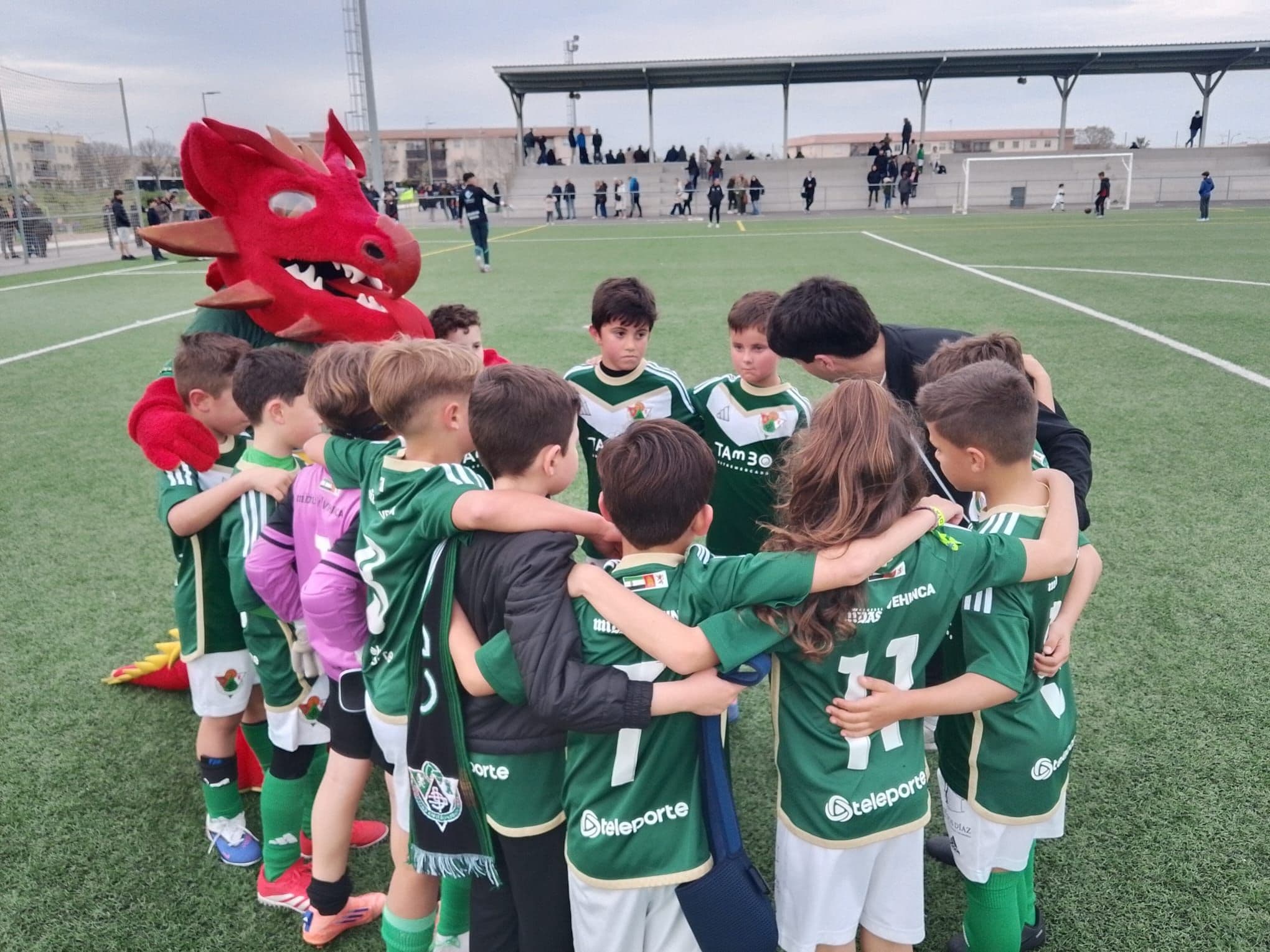 Dragoncito acompaña al Cacereño en un partido de fútbol base en Cáceres