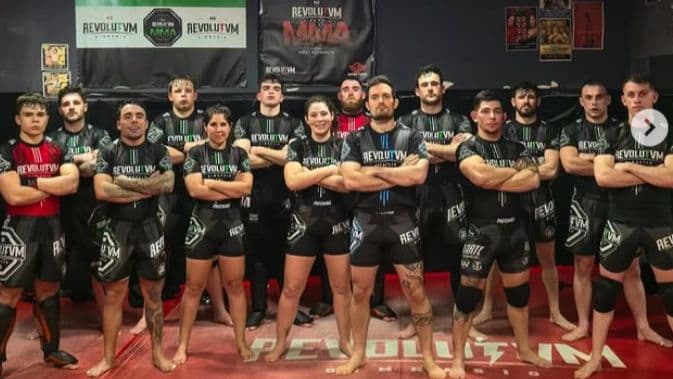 Luchadores del Team Revolutvm con la bandera de Extremadura